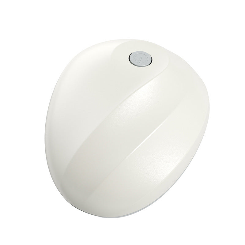 Top view of the white ELM & ECHO scalp massager showing its power button